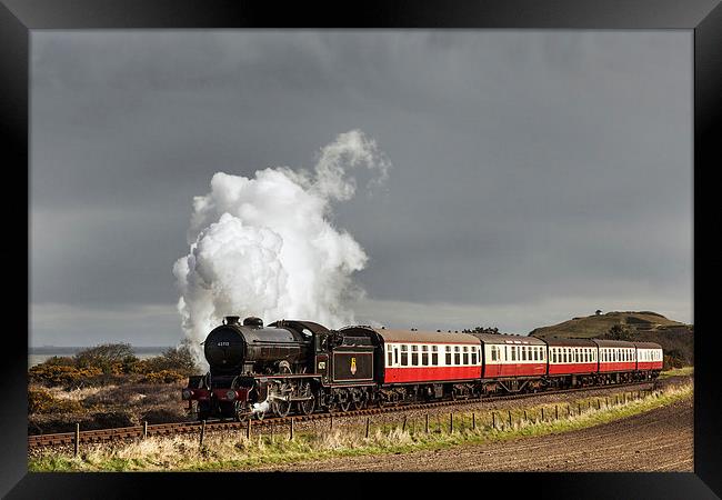 Steam train under storm clouds by the Coast Framed Print by Ian Duffield
