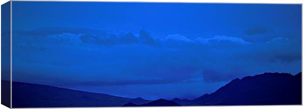  Blue skies over Silhouetted Mountains in Iceland Canvas Print by Sue Bottomley