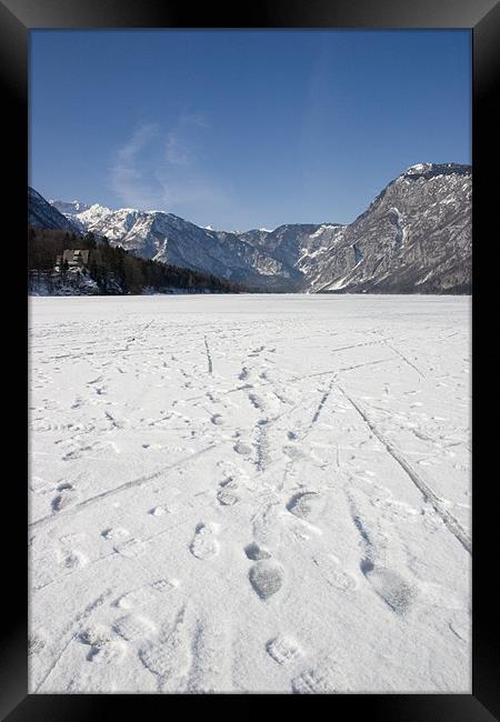 Footprints on a frozen lake Framed Print by Ian Middleton