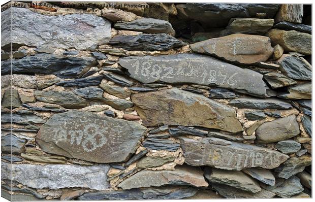 Old schist wall with several dates from the 19th c Canvas Print by Angelo DeVal