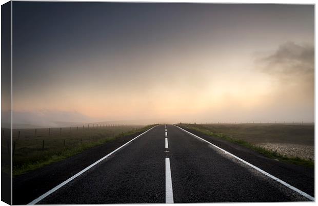  Road over the misty moors at sunset Canvas Print by Andrew Kearton