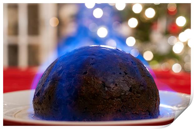 Christmas Pudding on a table, with a Christmas tre Print by Dave Carroll