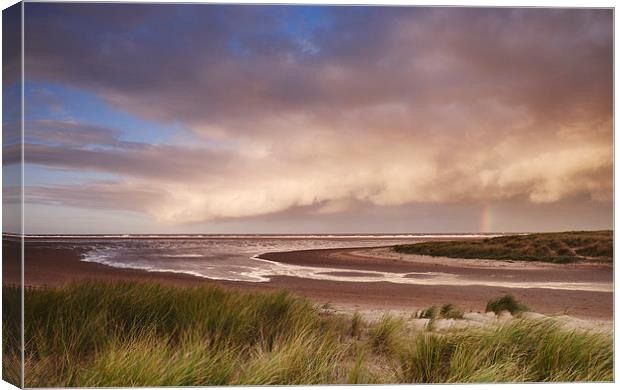 Storm clouds and rainbow at sunset. Holkham, Norfo Canvas Print by Liam Grant