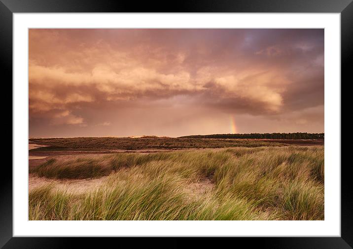 Storm clouds and rainbow at sunset. Holkham, Norfo Framed Mounted Print by Liam Grant