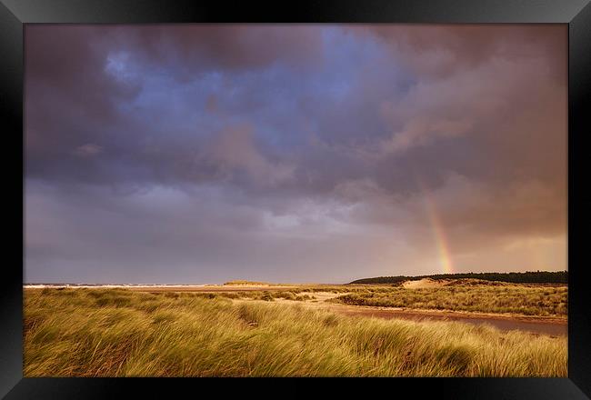 Storm clouds and rainbow at sunset. Holkham, Norfo Framed Print by Liam Grant