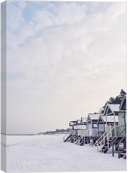 Beach huts covered in snow at low tide. Wells-next Canvas Print by Liam Grant