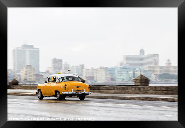 Yellow taxi hurtling down the Malecon Framed Print by Jason Wells