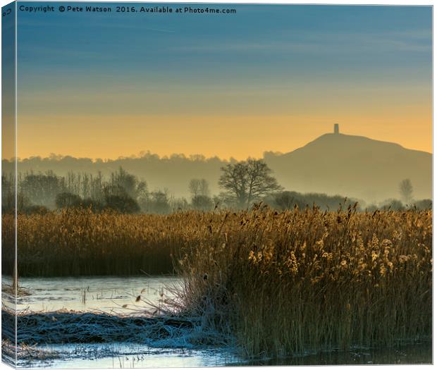 Glastonbury Tor shrouded in early morning mist. Canvas Print by Pete Watson