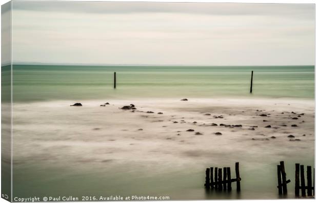 Wooden posts in the sea. Canvas Print by Paul Cullen