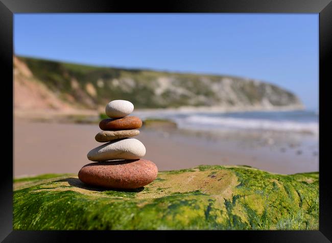 Pebbles Stacked on the beach in Swanage Dorset  Framed Print by Shaun Jacobs