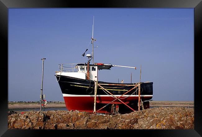 Red and black fishing boat on Lindisfarne Framed Print by Simon Marshall