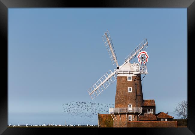 Flock of birds take to the skies behind Cley windm Framed Print by Jason Wells
