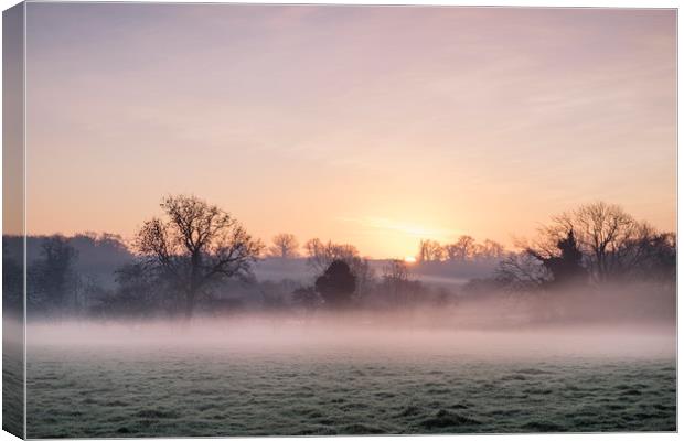 Sunrise and mist on a frosty morning. Norfolk, UK. Canvas Print by Liam Grant