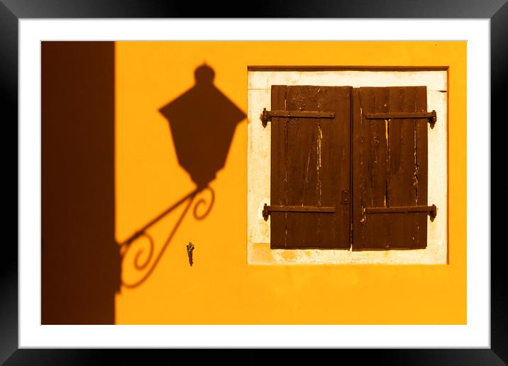 Street lamp shadow on a yellow wall. Framed Mounted Print by Tartalja 