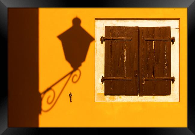 Street lamp shadow on a yellow wall. Framed Print by Tartalja 