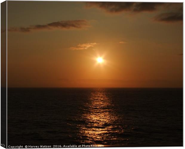 Golden setting sun on sea Canvas Print by Harvey Watson