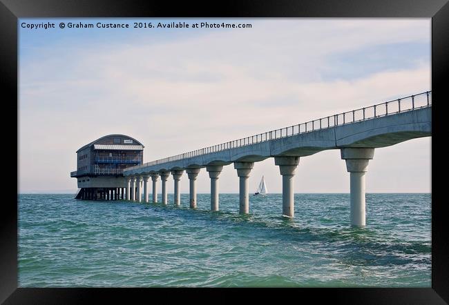 A yacht sails past Bembridge lifeboat station on t Framed Print by Graham Custance