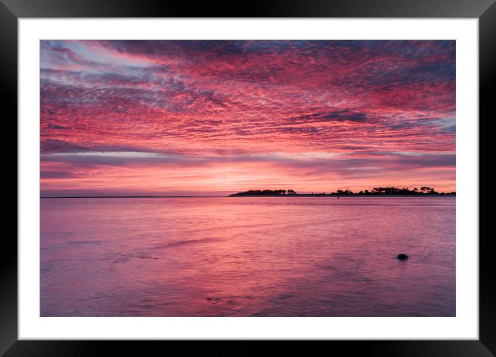 Pink dawn sky reflected in the surface of the sea. Framed Mounted Print by Liam Grant