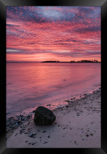 Pink dawn sky reflected in the surface of the sea. Framed Print by Liam Grant