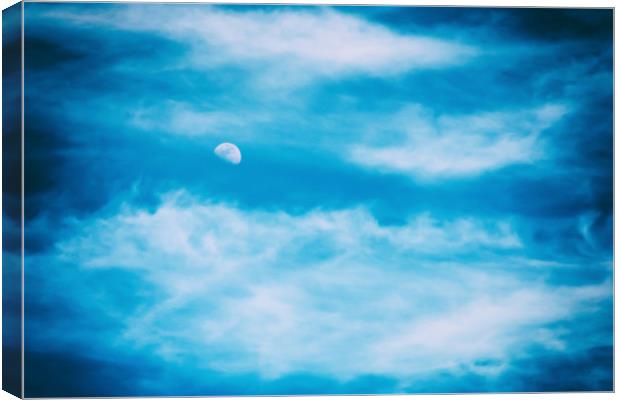 Moon Visible In Blue Sky With White Soft Clouds Canvas Print by Radu Bercan