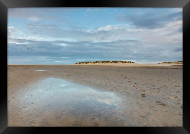 Sunset sky reflected in a water at low tide. Wells Framed Print by Liam Grant