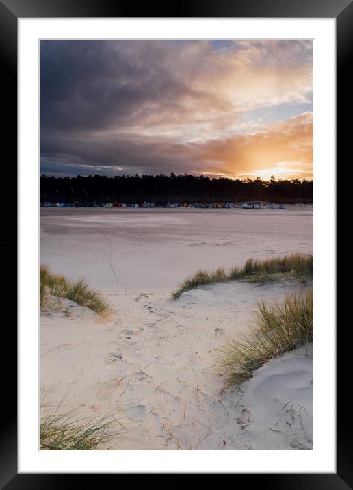 Sunset, beach huts and footprints in the sand. Nor Framed Mounted Print by Liam Grant
