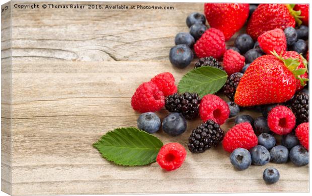 Freshly picked berries on rustic wooden boards Canvas Print by Thomas Baker