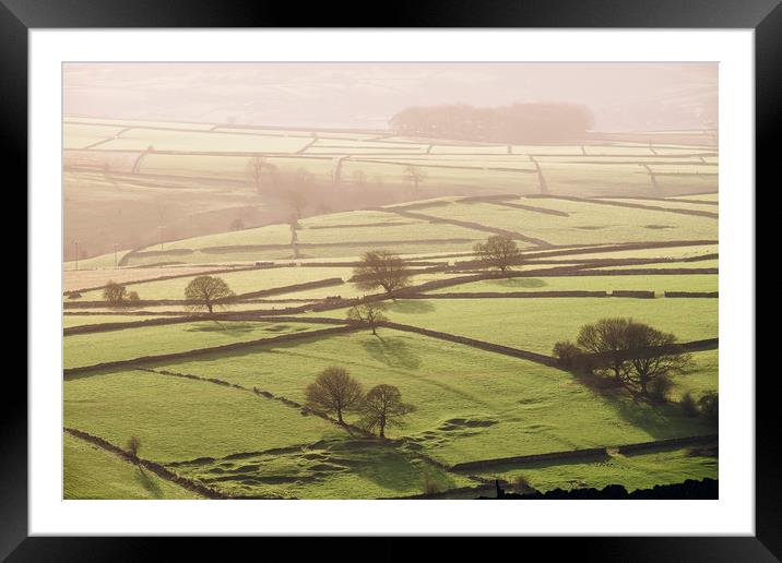 Hazy light at sunset over a valley of fields. Derb Framed Mounted Print by Liam Grant