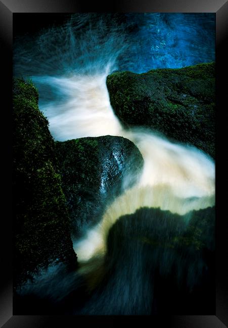 Flow between dark rocks Framed Print by Andrew Kearton