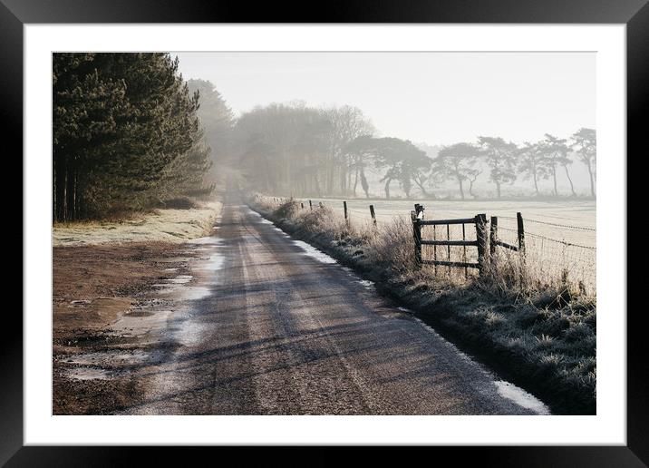 Remote frozen country road at sunrise. Norfolk, UK Framed Mounted Print by Liam Grant