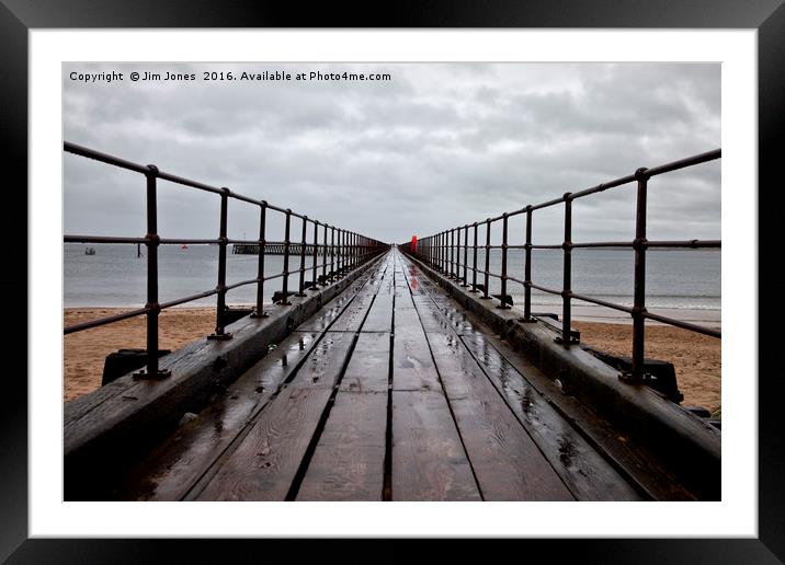 Wet wooden pier Framed Mounted Print by Jim Jones