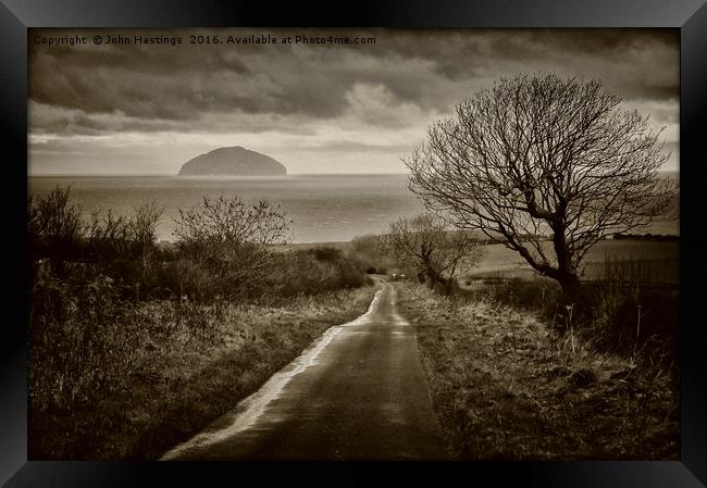 Ancient volcanic island off Scottish coast Framed Print by John Hastings