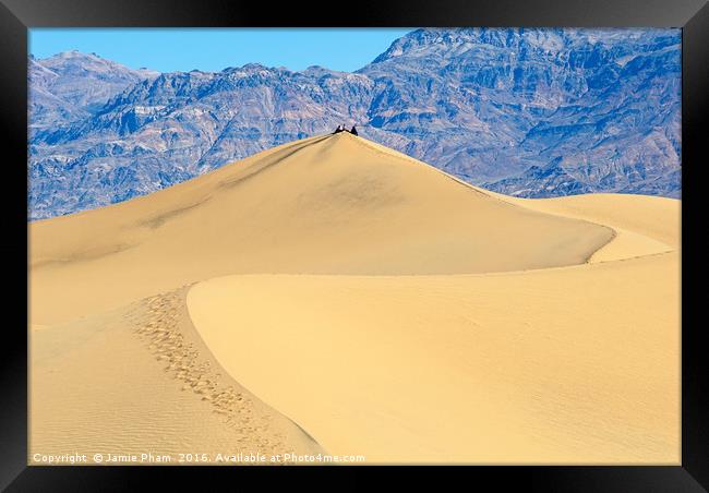 People sitting on top of a large sand dune in Deat Framed Print by Jamie Pham