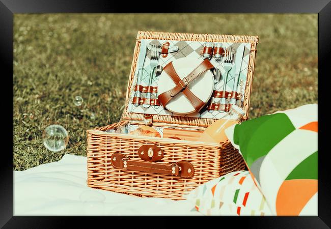 Picnic Basket Food On White Blanket With Pillows A Framed Print by Radu Bercan