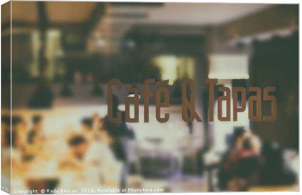 Cafe And Tapas Restaurant Sign With Blurred People Canvas Print by Radu Bercan