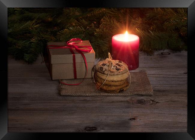Neatly tied fresh cookies with warm glowing candle Framed Print by Thomas Baker