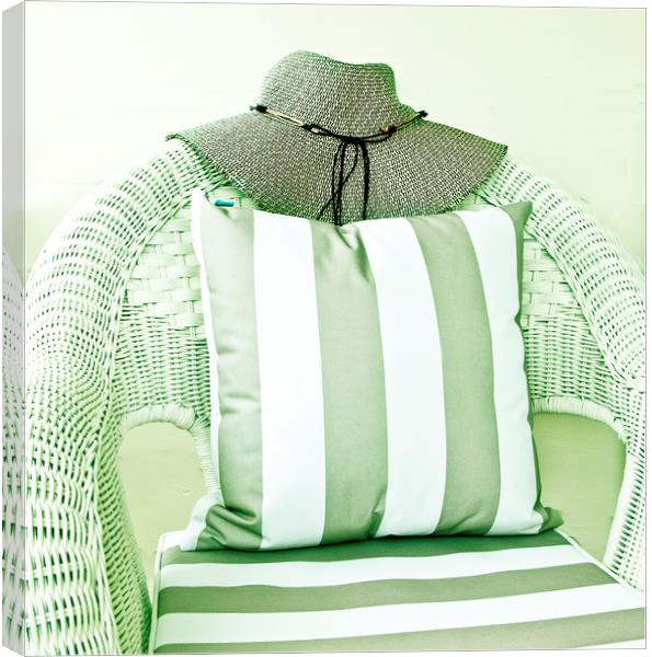 Hat on wicker chair with cushion Canvas Print by David Bigwood