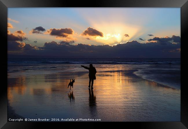 Walking the Dog at Sunset on Dunraven Bay Beach Framed Print by James Brunker