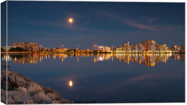 The moon and cityscape lights, reflect off harbour Canvas Print by Alan Hill