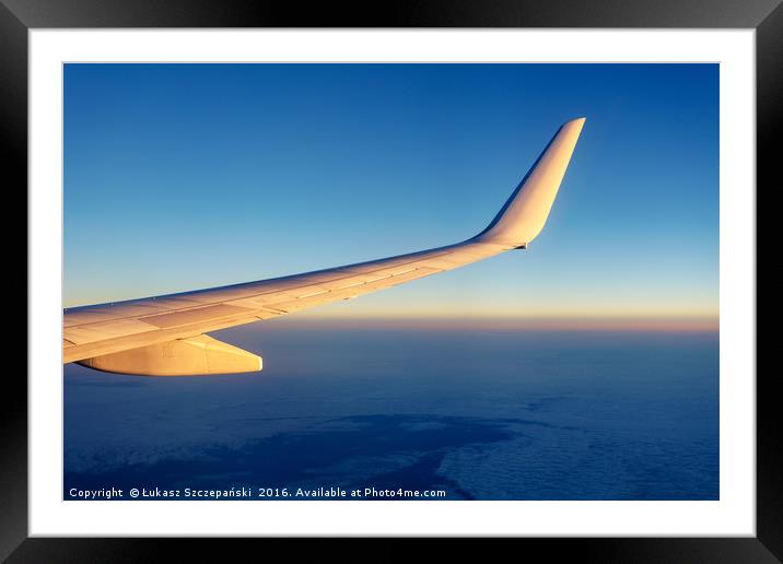 Wing of flying Boeing 737-800 against evening sky Framed Mounted Print by Łukasz Szczepański