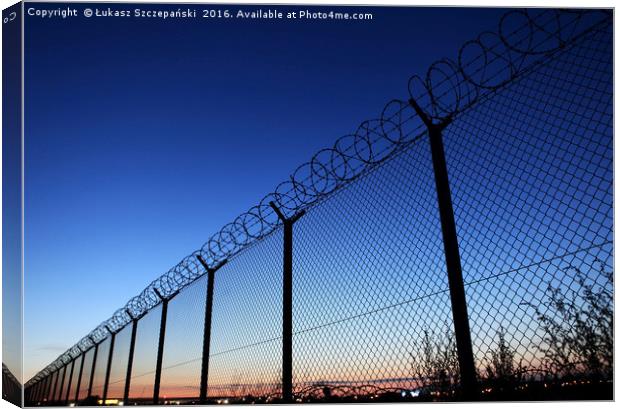 Restricted area fence against dark blue sky Canvas Print by Łukasz Szczepański