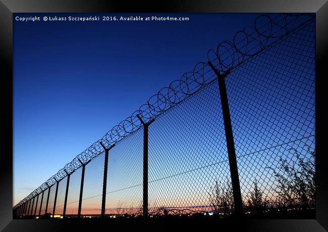 Restricted area fence against dark blue sky Framed Print by Łukasz Szczepański