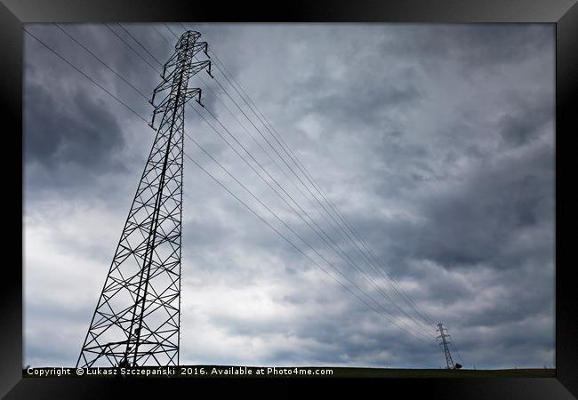 High-voltage power line against dark stormy clouds Framed Print by Łukasz Szczepański