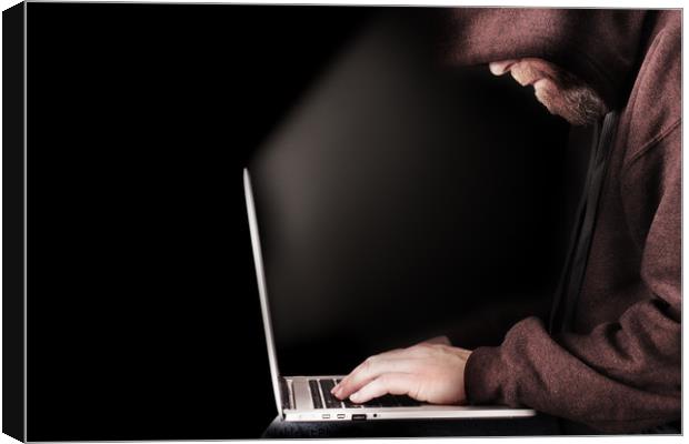 Hooded computer hacker using laptop Canvas Print by Simon Bratt LRPS