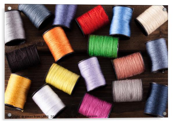 Colorful cotton reels scattered on dark wood Acrylic by Simon Bratt LRPS