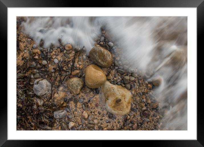 Pebbles being washed over by the incoming tide. Framed Mounted Print by Bryn Morgan