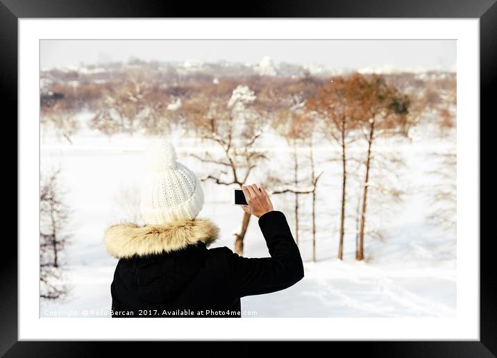 Cute Girl Taking Photos With Mobile Phone In Winte Framed Mounted Print by Radu Bercan