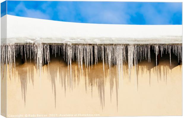 House Roof Covered In Snow And Dangerous Icicles Canvas Print by Radu Bercan