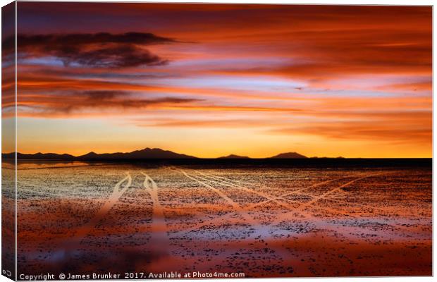 Vehicle tracks on surface of Salar de Uyuni at sun Canvas Print by James Brunker