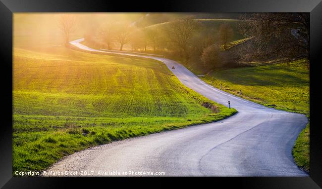 Road in a tuscan landscape at sunset  Framed Print by Marco Bicci